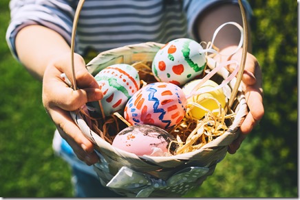 Colorful Easter eggs in basket. Kids hunt for eggs outdoors.