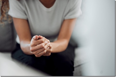 Hands, psychology and mental health with a woman in a therapy session for grief counseling after loss. Anxiety, stress or depression with a female patient feeling nervous in a clinic for support