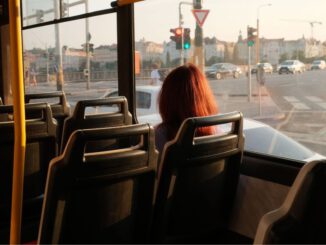 Pasajero utilizando sistema de pago automático en un autobús moderno para evitar conflictos con el conductor