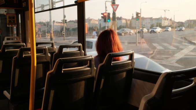 Pasajero utilizando sistema de pago automático en un autobús moderno para evitar conflictos con el conductor