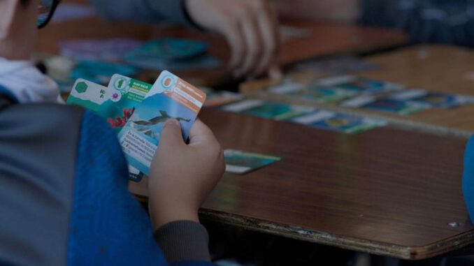 Jugadores participando en una partida competitiva del juego de mesa ILAN sobre la Antártica