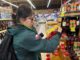 Fiscalizadores del Servicio Agrícola y Ganadero revisando etiquetas de botellas de alcohol en un establecimiento comercial