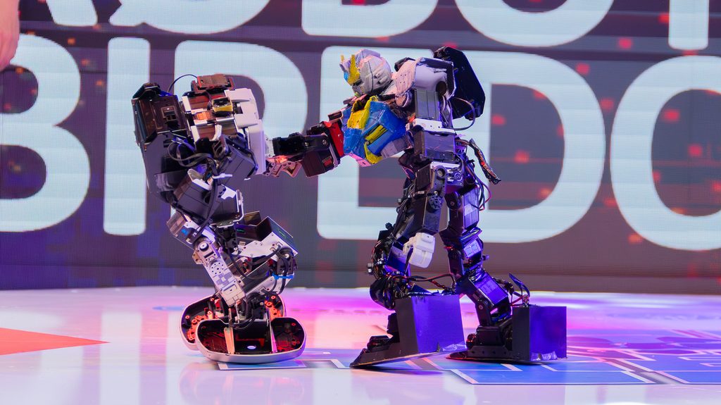 Estudiantes participando en competencias de robótica y tecnología en el evento Arena IV en Concepción.