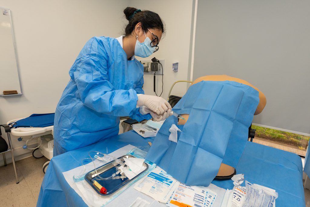Estudiante de medicina practicando un procedimiento médico en un entorno de simulación clínica segura