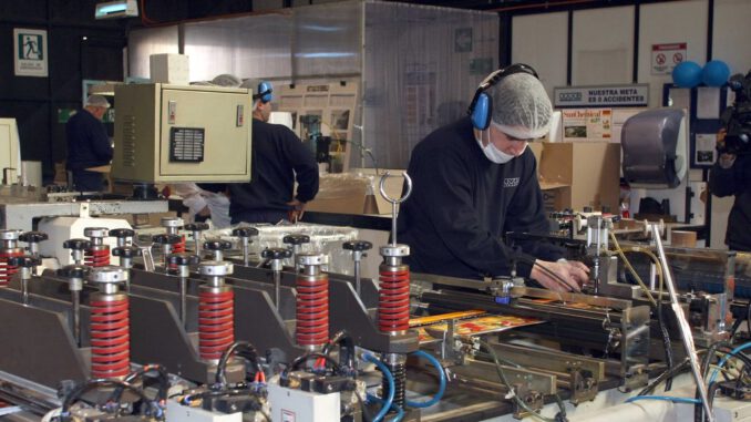 Trabajadores en una planta industrial del sector manufacturero en la region del Biobio analizando pantallas digitales