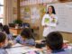 Estudiantes universitarios compartiendo literatura infantil en inglés con escolares en un aula